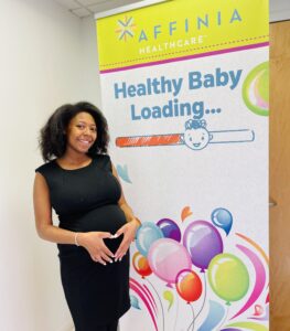 expectant mom in front of pop up banner midwife page