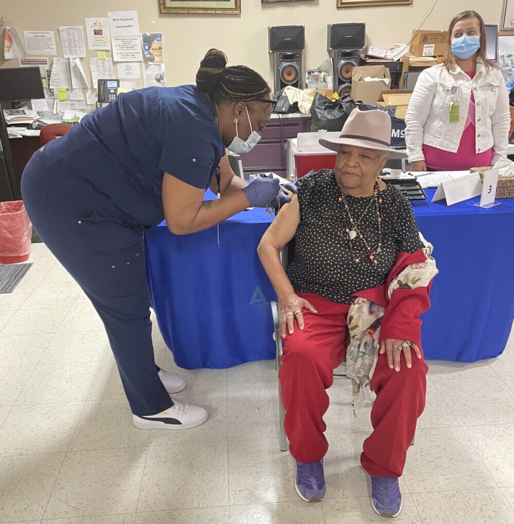 iris gives vaccine to ollie stewart southside wellness center