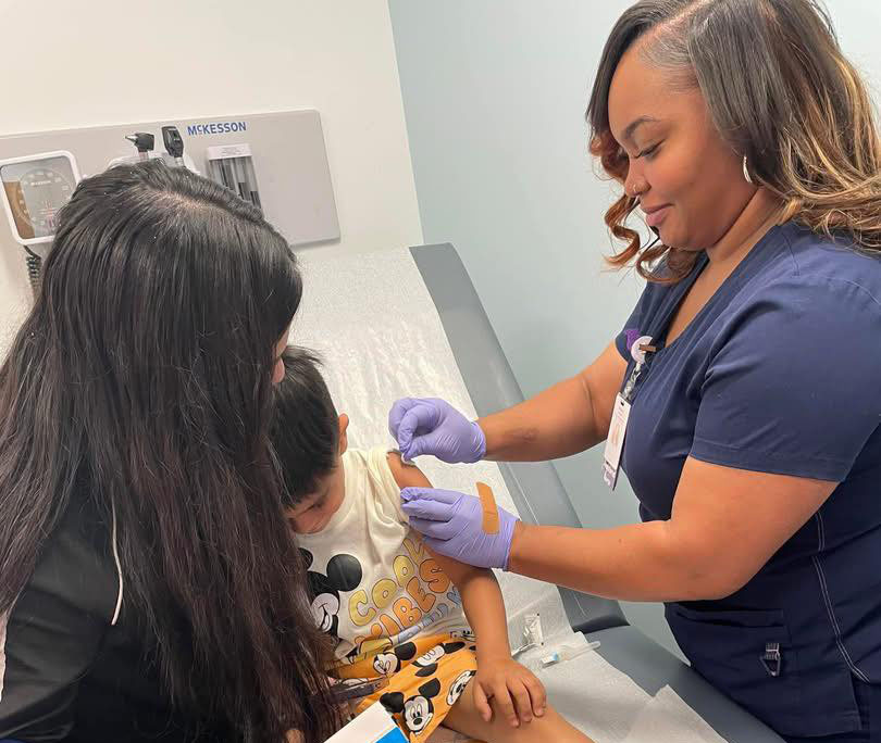 nurse robinson gives child a shot